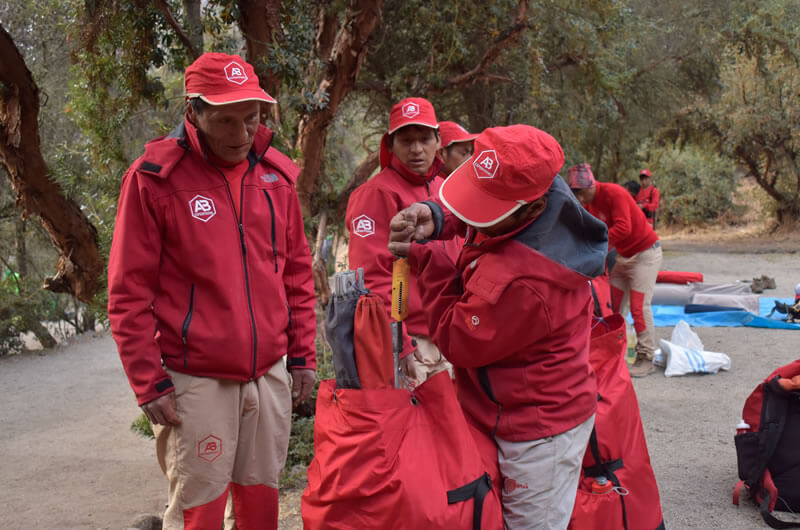 our inca trail porter weighing his backpack