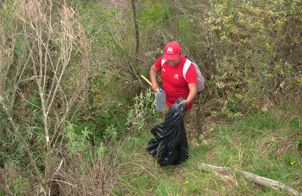 PIcking up plastic bottle in huchuy qosqo trek 